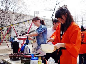 スパニッシュオムレツを焼くルーマニア人留学生と国際交流愛好会の学生