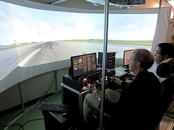 国際エンジニアコース演習室に設置してあるフライトシュミレータを操縦するケニー国際部長
