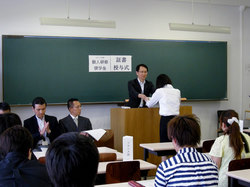 八王子キャンパスA209にて、山田政通国際交流留学生センター長より証書授与